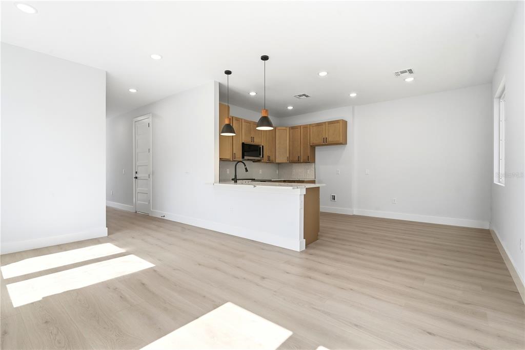 A kitchen with light wood cabinets and a breakfast bar overlooks an open living area — 1232 VIRGINIA DRIVE, ORLANDO, FL