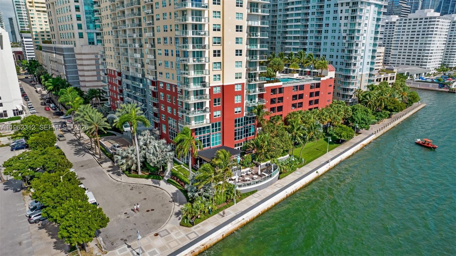 An aerial view shows a tall apartment building with a waterfront patio and pool deck — 1155 Brickell Bay Dr # 2203, Miami FL 33131, MIAMI, FL