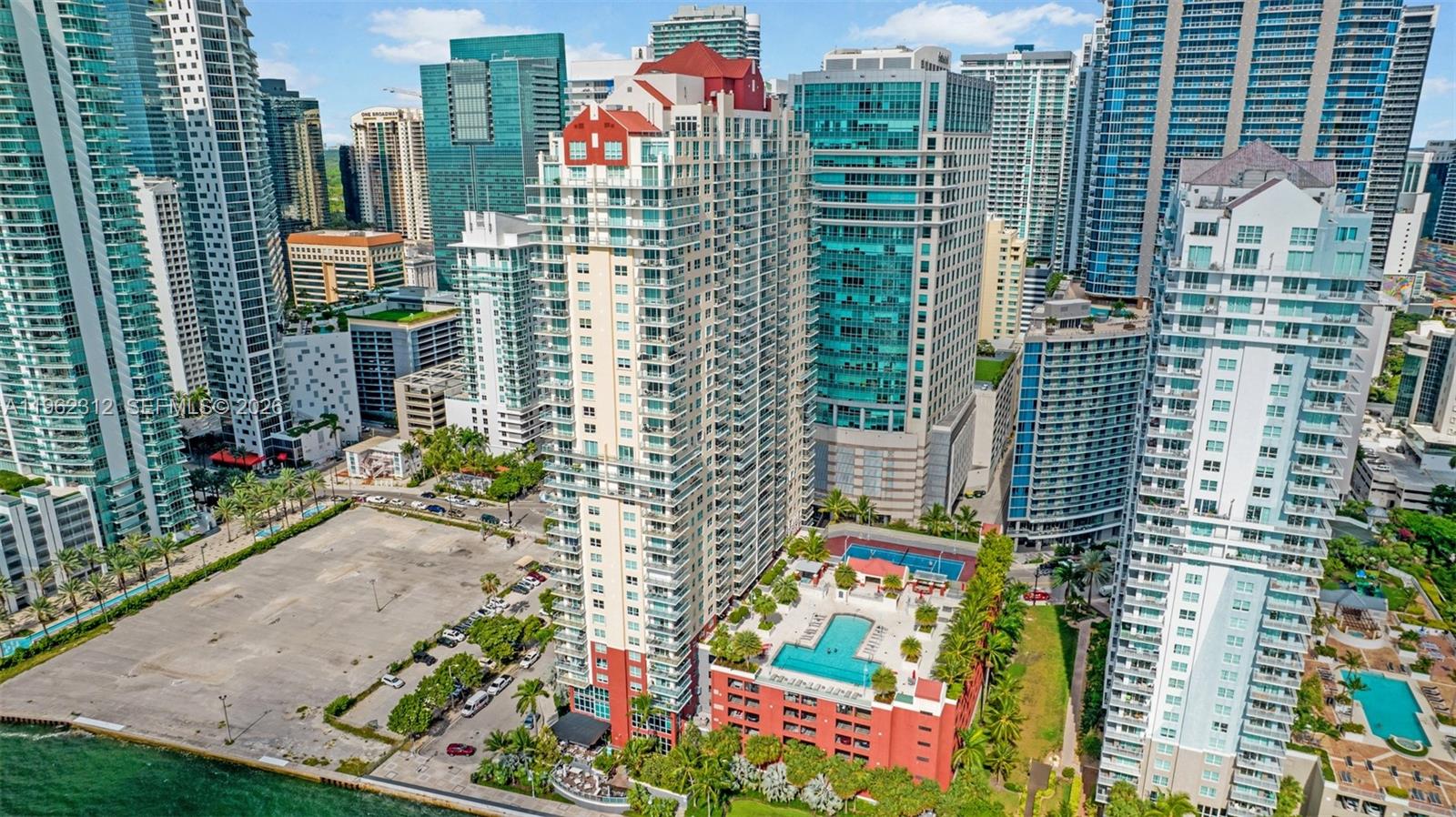 An aerial view of a tall residential building with a pool deck in a city — 1155 Brickell Bay Dr # 2203, Miami FL 33131, MIAMI, FL