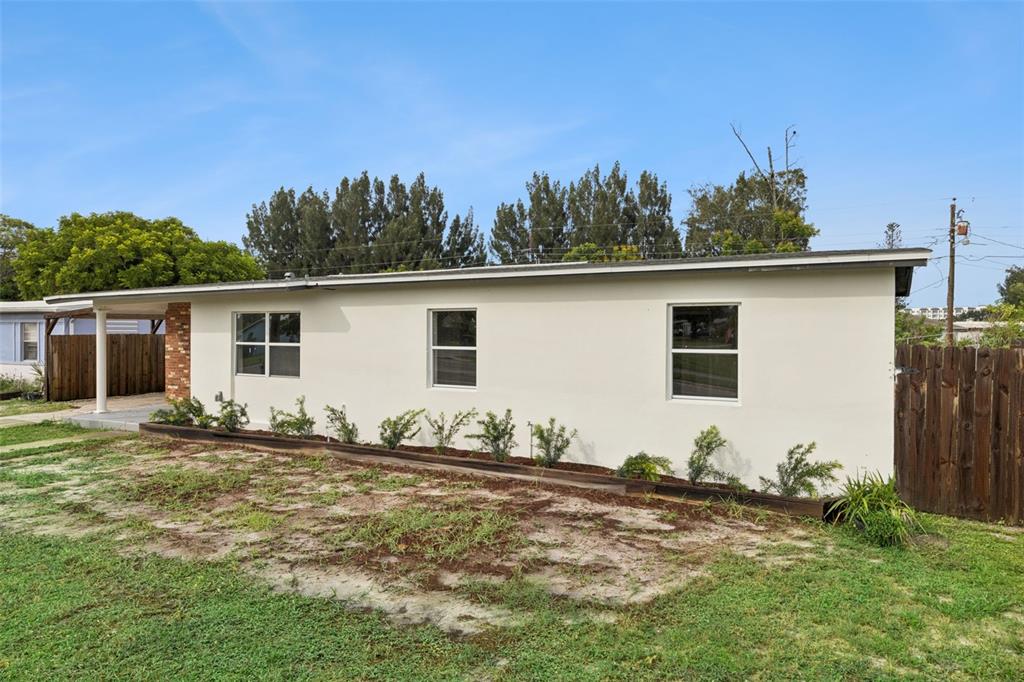 A single-story house with a white exterior, a covered porch, and a wooden fence — 1061 BIANCA DRIVE NE, PALM BAY, FL
