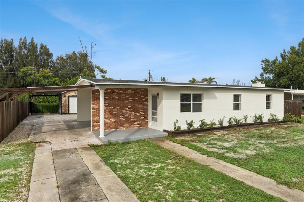 A single-story house with a brick accent wall, a carport, and a concrete driveway — 1061 BIANCA DRIVE NE, PALM BAY, FL