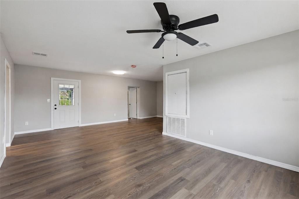 An empty room with light gray walls, dark wood-look flooring, and a ceiling fan — 1061 BIANCA DRIVE NE, PALM BAY, FL