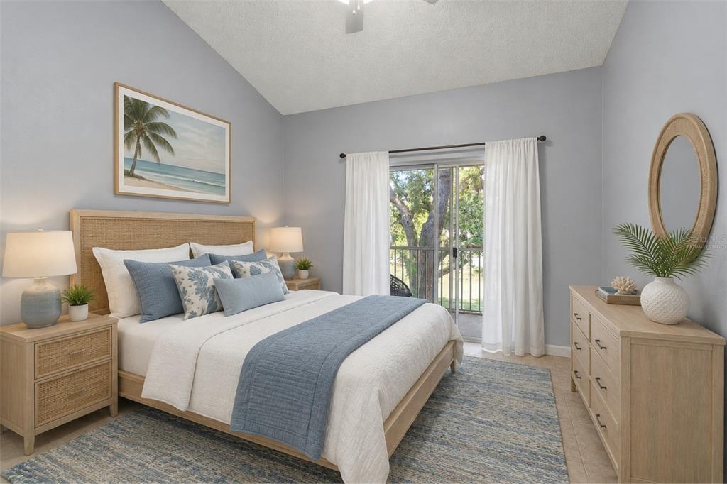 A bedroom features a queen bed, light wood furniture, a blue area rug, and balcony access — 2832 OSPREY COVE PLACE UNIT 202, KISSIMMEE, FL