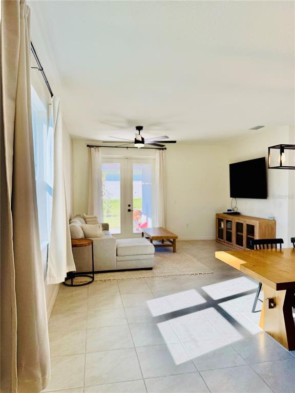A living room features light tile floors, a sectional sofa, and a wall-mounted television — 639 ALDER LANE, AUBURNDALE, FL