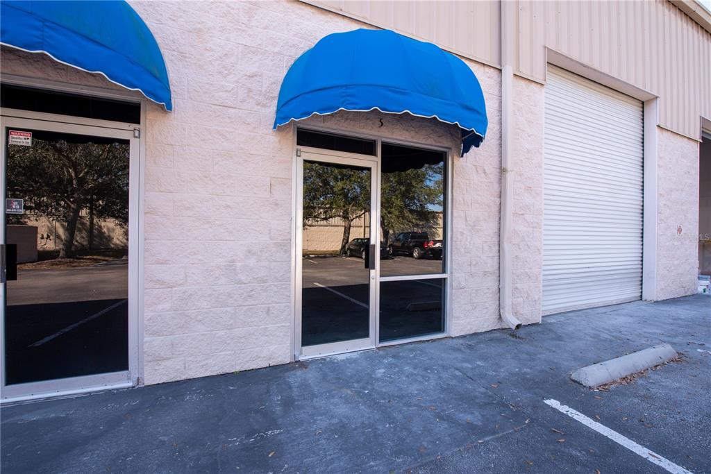 The exterior of a commercial building features two glass doors with blue fabric awnings — 7307 SANDSCOVE COURT UNIT 5, WINTER PARK, FL