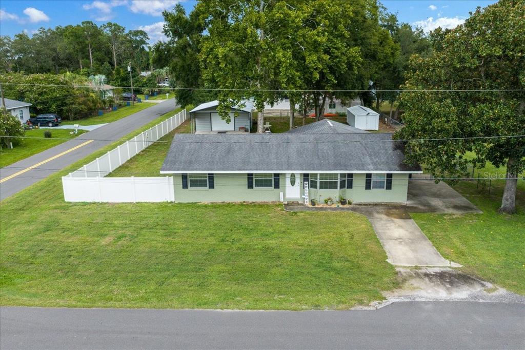 An aerial view shows a single-story house with a green exterior, gray roof, and driveway — 11793 SE 72ND TERRACE ROAD, BELLEVIEW, FL