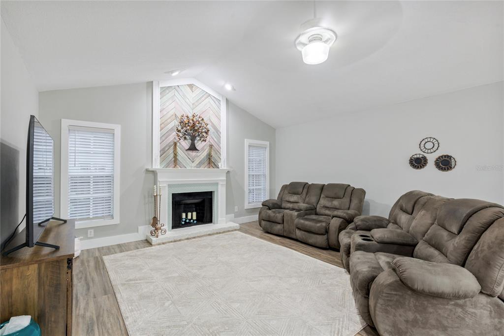 A kitchen with a gray island, white cabinets, and a dining area beside sliding doors — 2766 BUCKHORN OAKS DRIVE, VALRICO, FL
