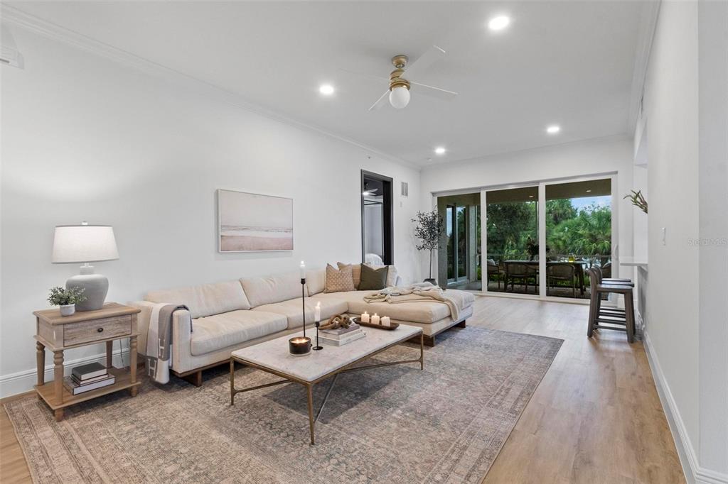 A living room features a sectional sofa, marble coffee table, and sliding glass doors to a patio — 455 RIVERFRONT DRIVE UNIT A104, PALM COAST, FL