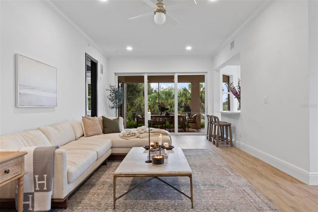 A living room features a sectional sofa, a coffee table, and sliding doors to a patio — 455 RIVERFRONT DRIVE UNIT A104, PALM COAST, FL