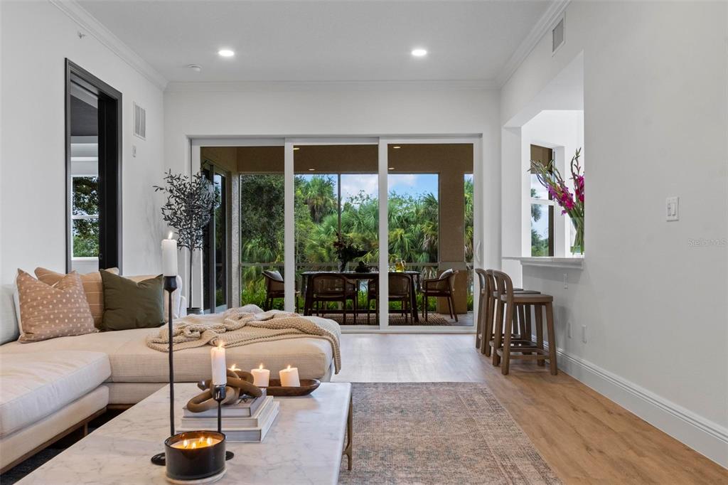 A living room with a sectional sofa, marble coffee table, and sliding doors to a patio — 455 RIVERFRONT DRIVE UNIT A104, PALM COAST, FL