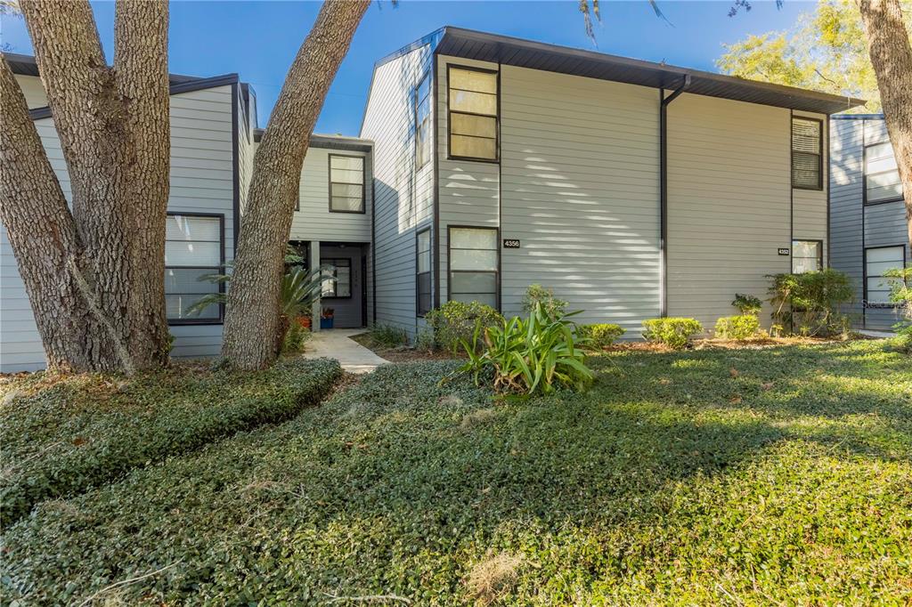 A two-story residential building with light gray siding and large trees in the front yard — 4356 SW 20TH LANE, GAINESVILLE, FL