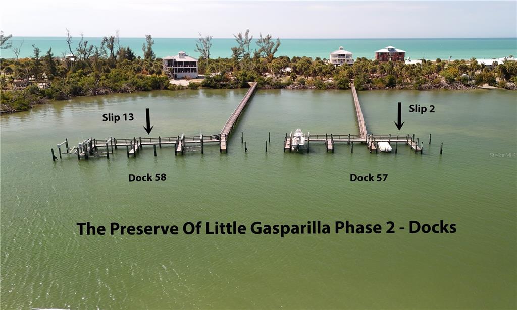 An aerial view shows two wooden boat docks extending into the water from a coastline — 9160 GRAND AVENUE, PLACIDA, FL