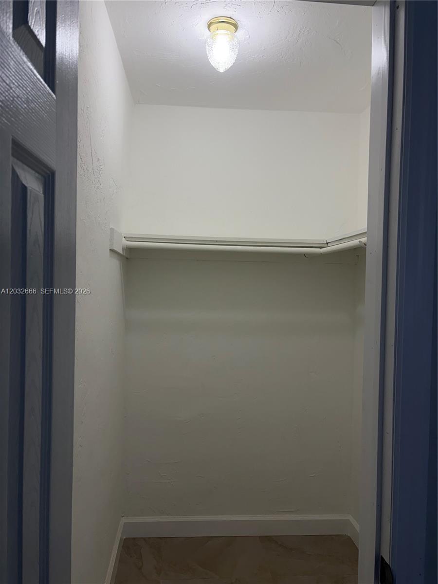 A small, empty closet features a single shelf, a hanging rod, and a ceiling light — 61 W 13th St # 1, Hialeah FL 33010, HIALEAH, FL