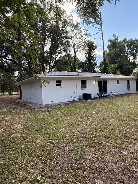 A white, single-story brick house with a hip roof sits on a grassy lot — 6989 SW STATE ROAD 26, TRENTON, FL