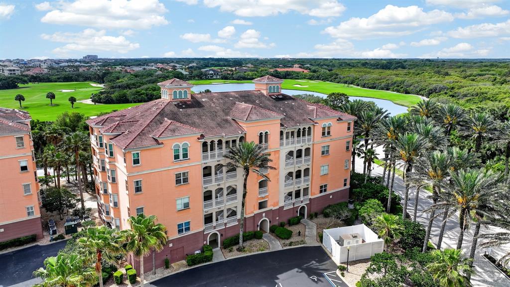 An aerial view shows a multi-story peach-colored apartment building next to a golf course — 35 OCEAN CREST WAY UNIT 1111, PALM COAST, FL
