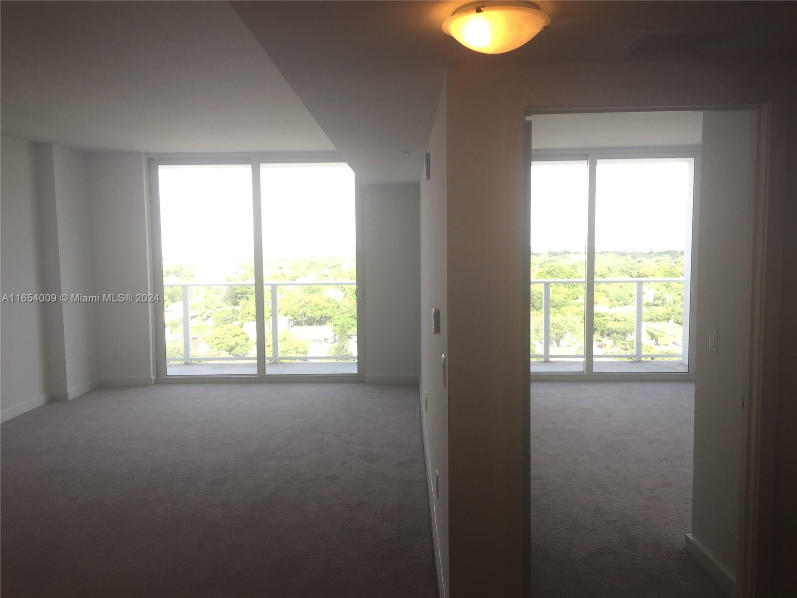 Two carpeted rooms with floor-to-ceiling windows overlook a green landscape — 4250 Biscayne Blvd # 1211, Miami FL 33137, MIAMI, FL
