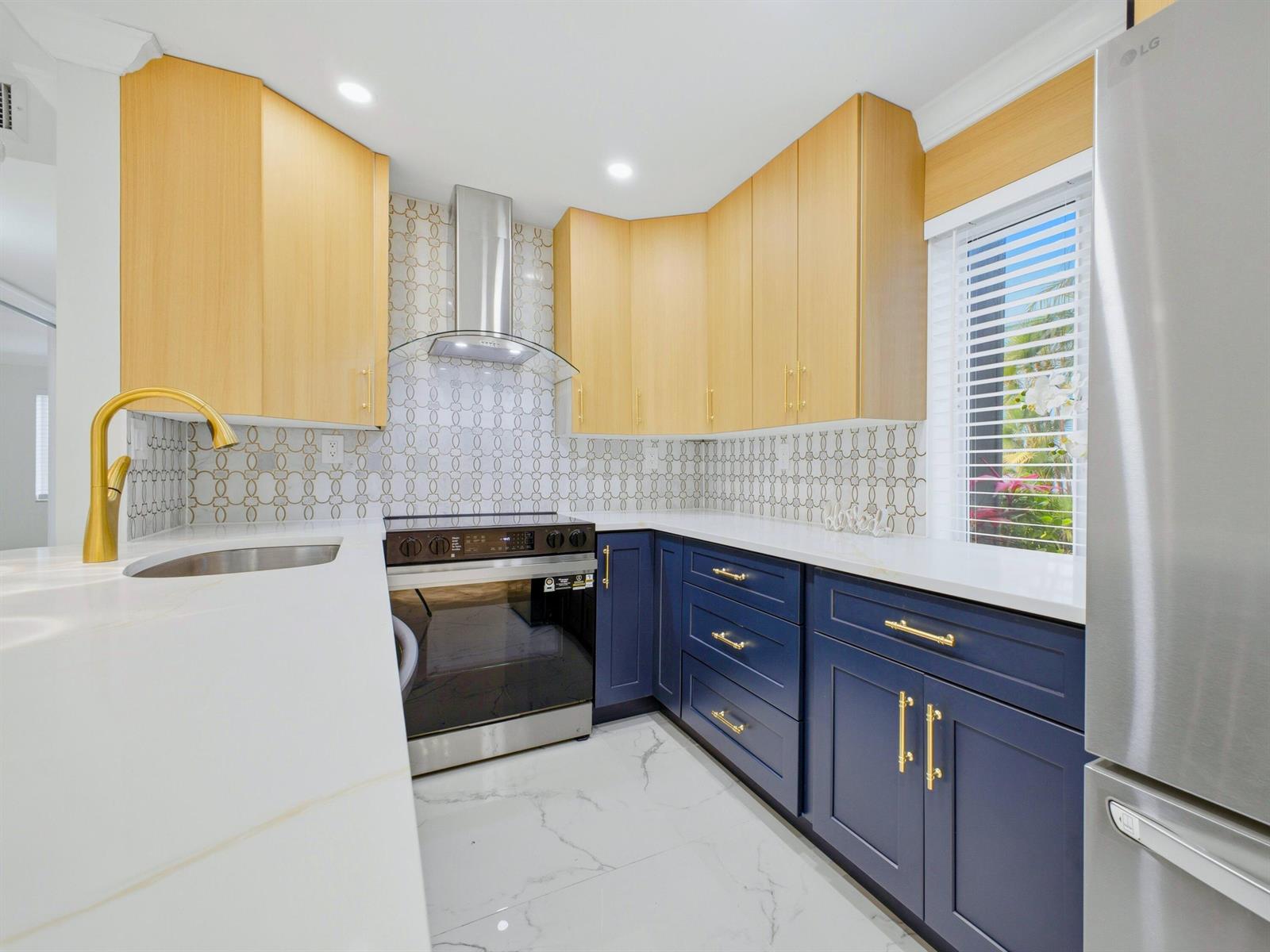 A kitchen features two-tone blue and light wood cabinets, white countertops, and a patterned backsplash — 6 Normandy A, Delray Beach FL 33484, DELRAY BEACH, FL