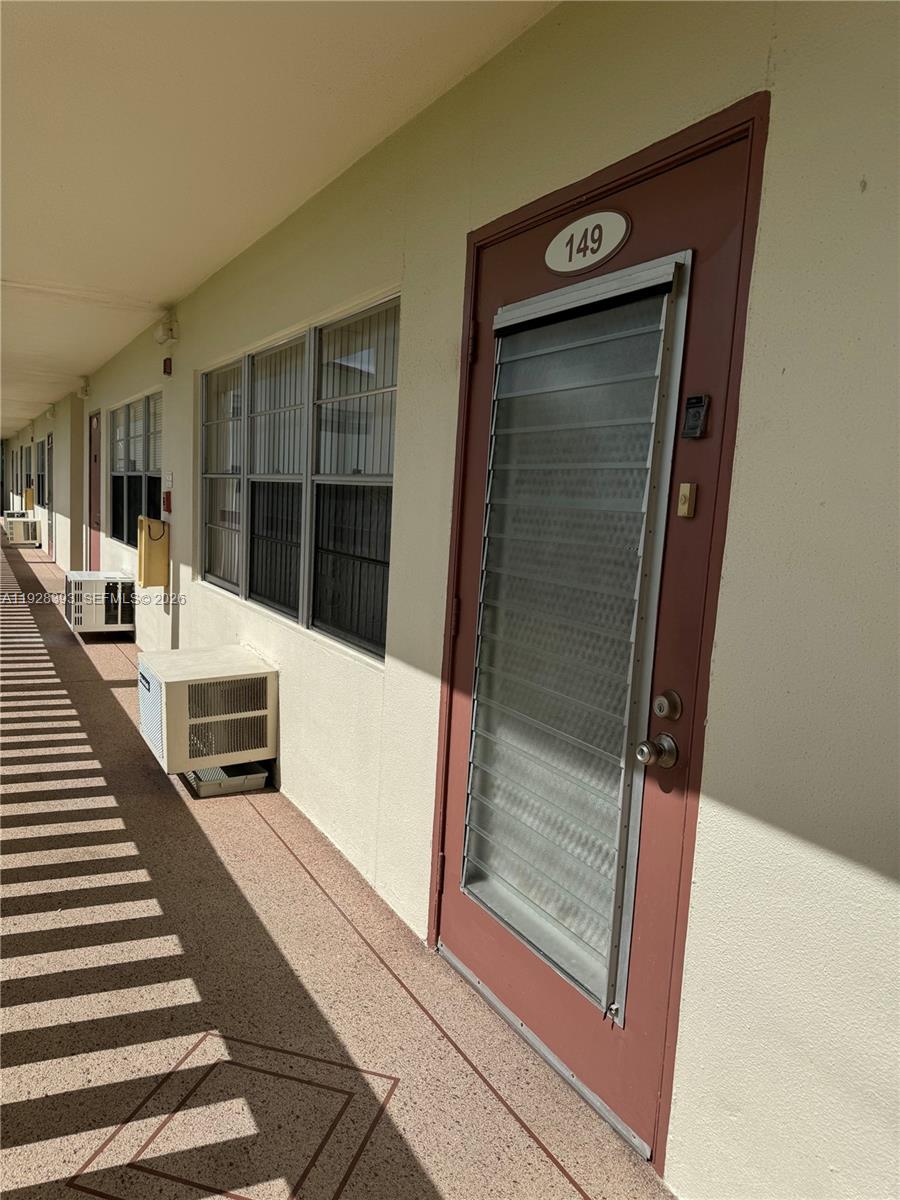 An exterior view of a building corridor showing a numbered door and window units — 149 Preston D # 149, Boca Raton FL 33434, BOCA RATON, FL