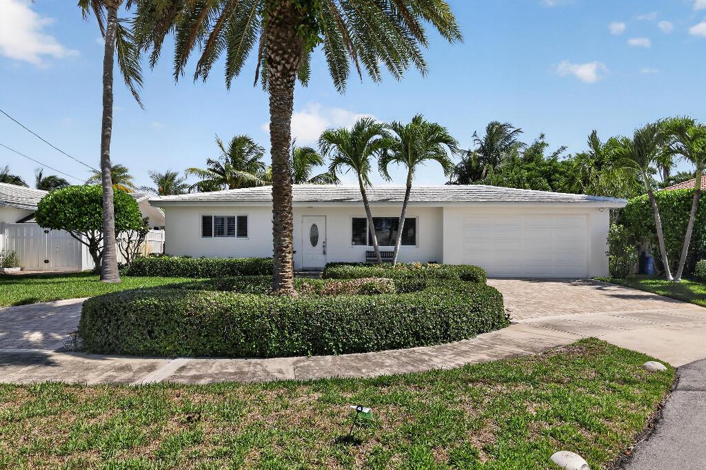 A white single-story house with a paved driveway, palm trees, and manicured hedges — 636 Kingfish Road, North Palm Beach FL 33408, NORTH PALM BEACH, FL