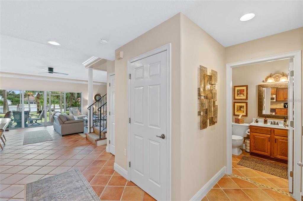 A tiled hallway leads to a living area with sliding glass doors and a small bathroom — 50 PALM HARBOR PARKWAY UNIT 32, PALM COAST, FL