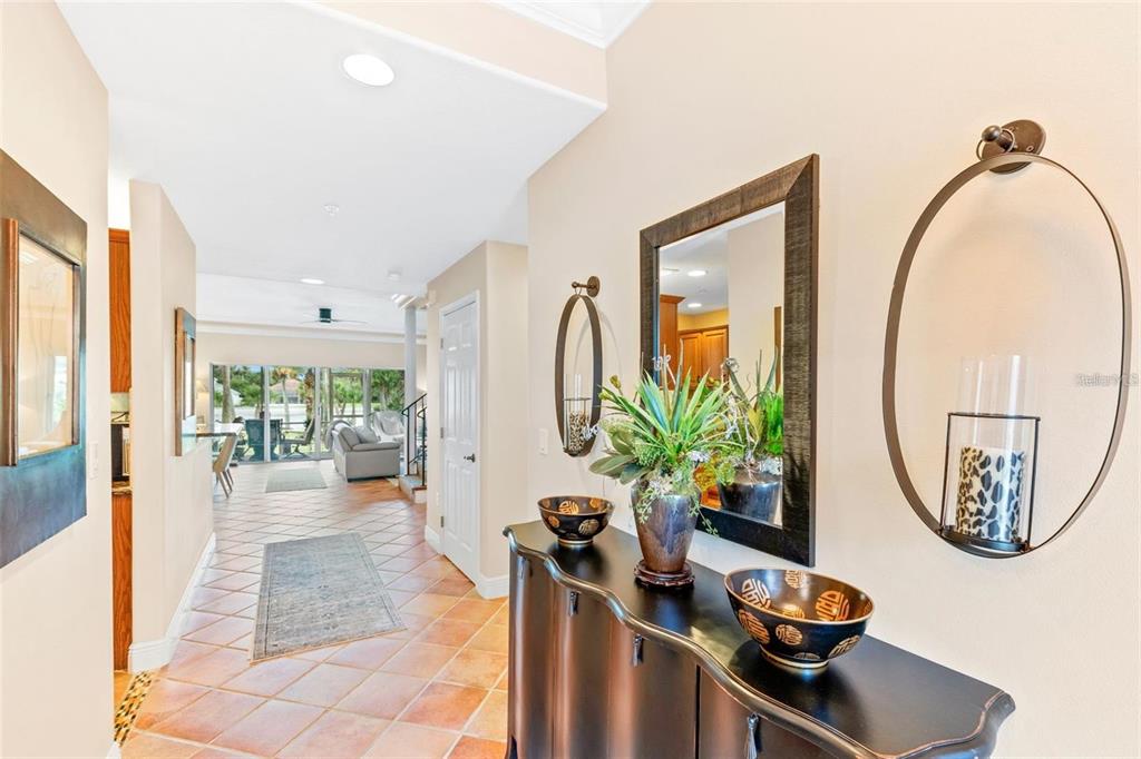 A hallway with tile floors leads to a living area with a view of the outdoors — 50 PALM HARBOR PARKWAY UNIT 32, PALM COAST, FL