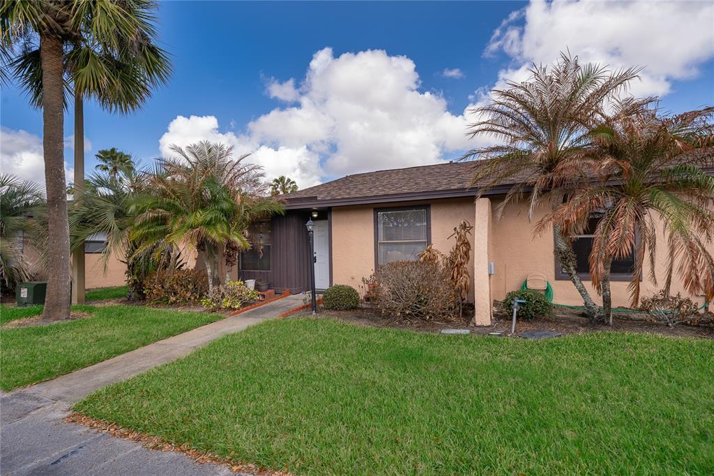A single-story tan house with a brown roof, palm trees, and a front walkway — 2123 ST MARTEEN COURT, KISSIMMEE, FL