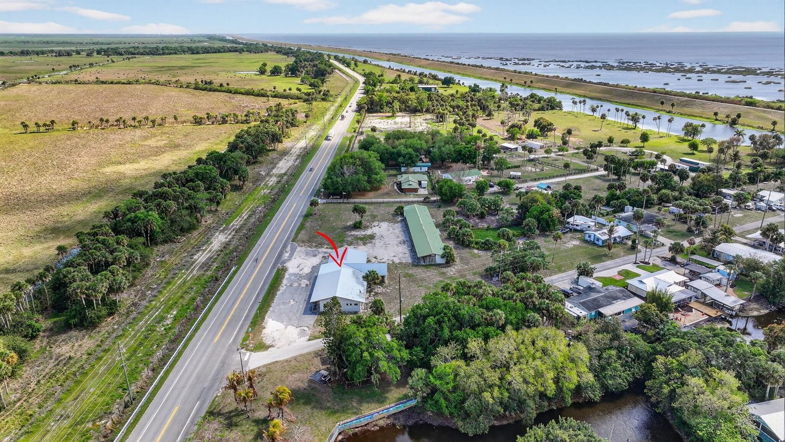 An aerial view shows a building with a red arrow next to a highway — 9700 SW Conners Highway, Okeechobee FL 34974, OKEECHOBEE, FL