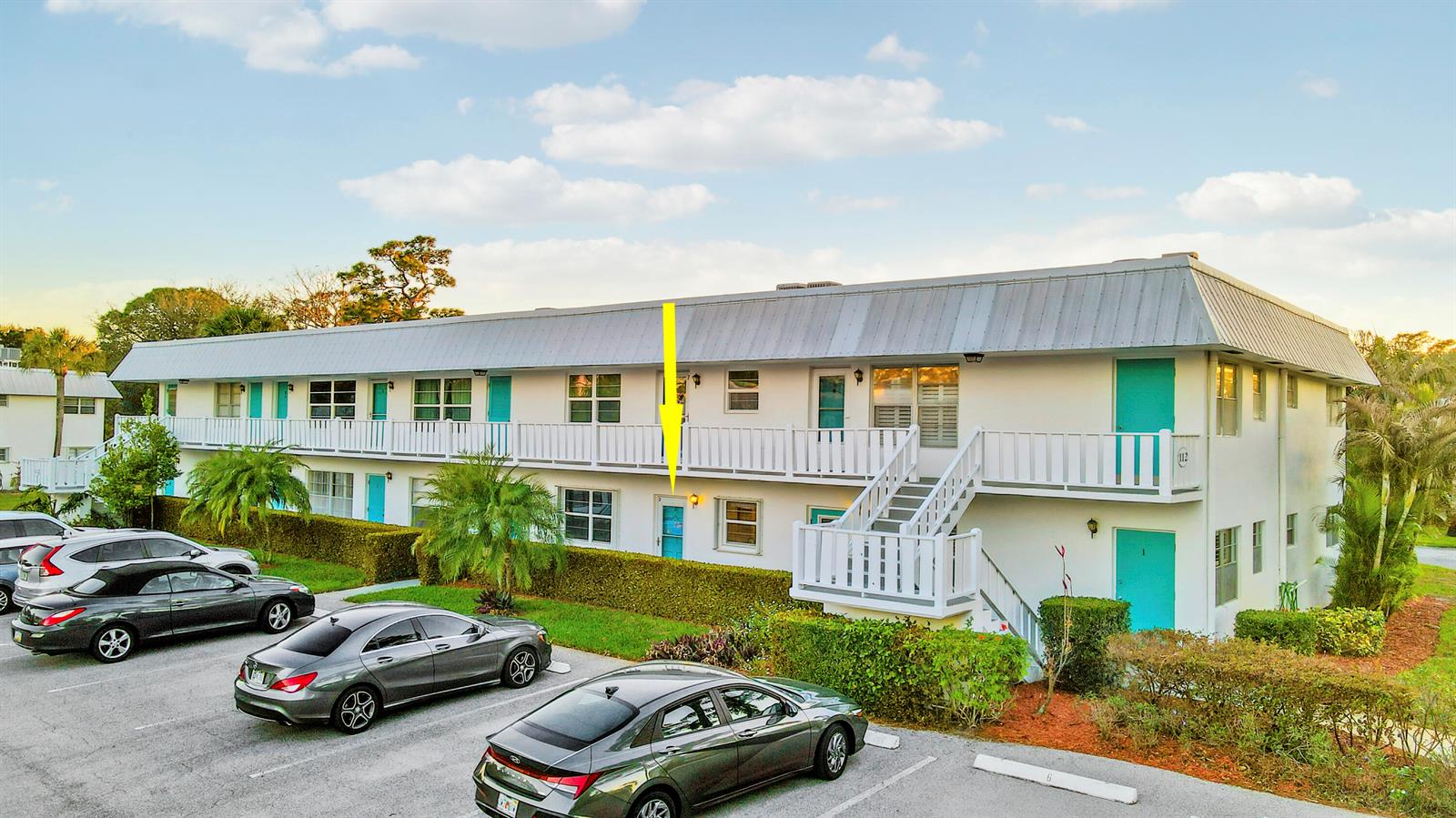 A two-story apartment building with a yellow arrow pointing to a ground-floor unit door — 2929 SE Ocean Boulevard # 2, Stuart FL 34996, STUART, FL