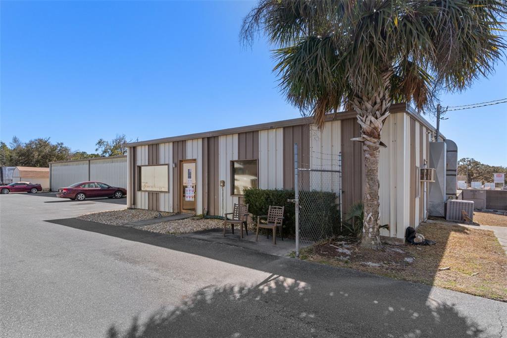 A single-story commercial building with metal siding, a palm tree, and a paved parking lot — 6331 & 6275 S TEX POINT, HOMOSASSA, FL