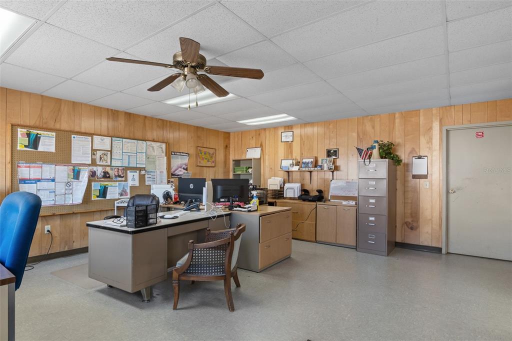 An office space features wood-paneled walls, a drop ceiling, a desk, and a filing cabinet — 6331 & 6275 S TEX POINT, HOMOSASSA, FL