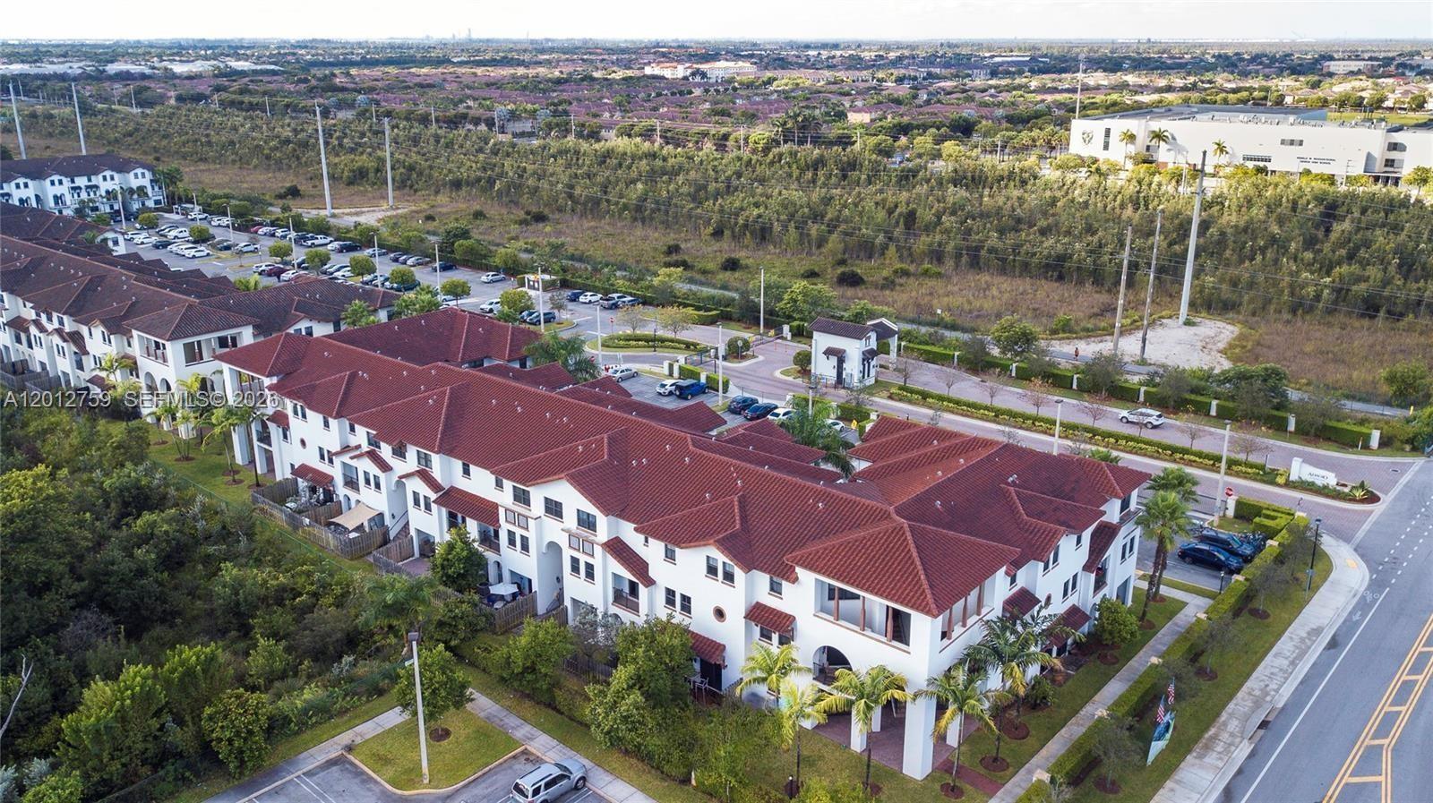 An aerial view shows a multi-story residential townhouse complex with red tile roofs — 10620 NW 88th St # 205, Doral FL 33178, DORAL, FL