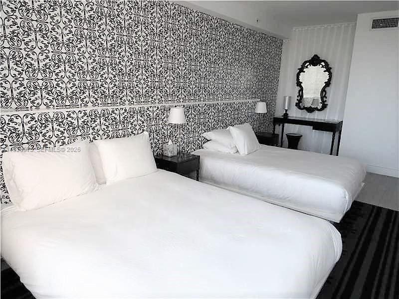 A bedroom features two beds against a wall with bold black and white patterned wallpaper — 1100 West Ave # 517, Miami Beach FL 33139, MIAMI BEACH, FL