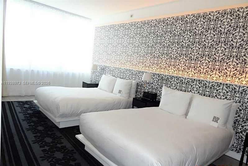 A bedroom features two beds against a wall with patterned black and white wallpaper — 1100 West Ave # 517, Miami Beach FL 33139, MIAMI BEACH, FL