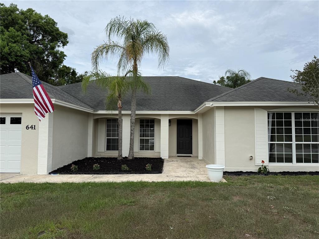 A single-story house with a beige exterior, a palm tree, and an American flag — 641 BROOKSIDE ROAD, MAITLAND, FL