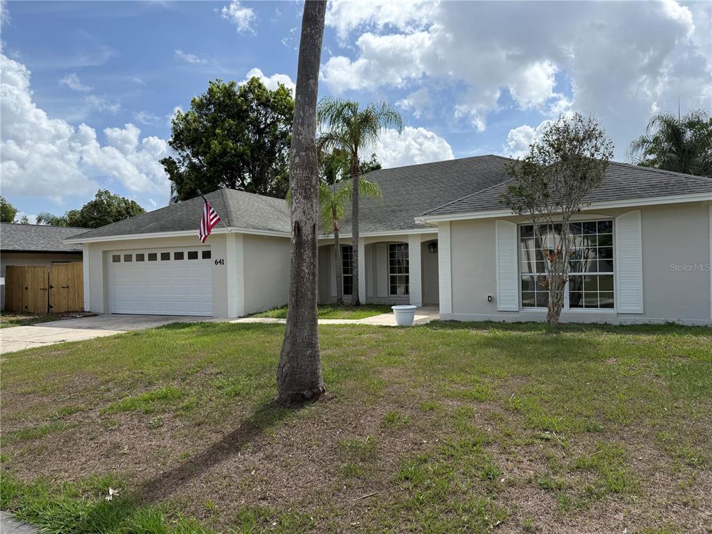 A single-story house with a white garage, beige exterior, and a front lawn — 641 BROOKSIDE ROAD, MAITLAND, FL