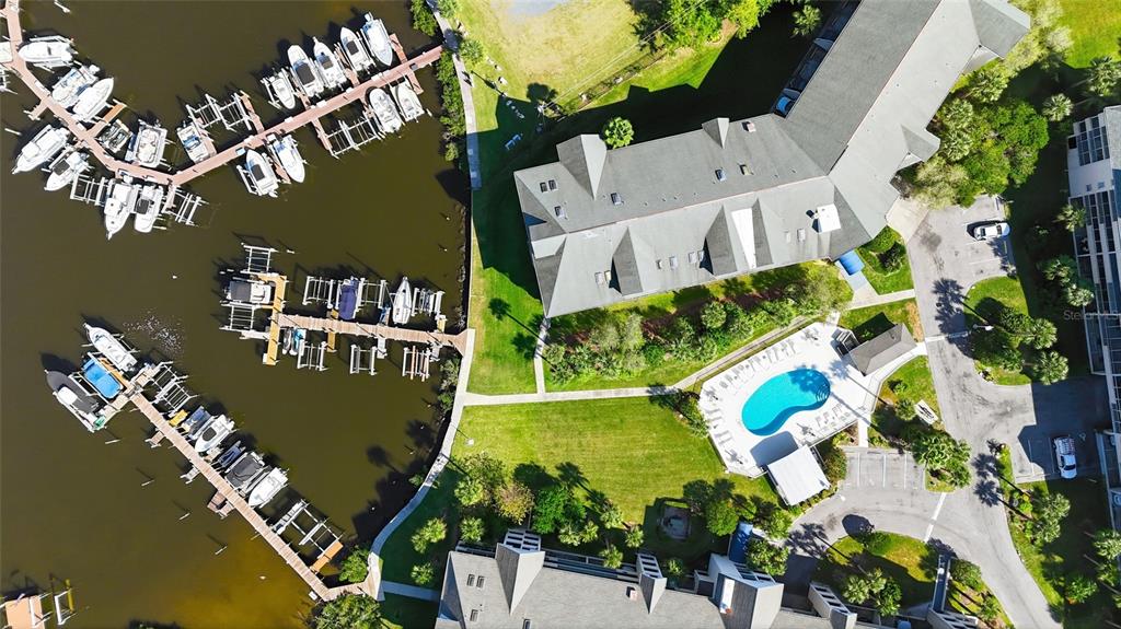 An aerial view shows a multi-story building, a swimming pool, and a boat marina — 5567 SEA FOREST DRIVE UNIT 323, NEW PORT RICHEY, FL