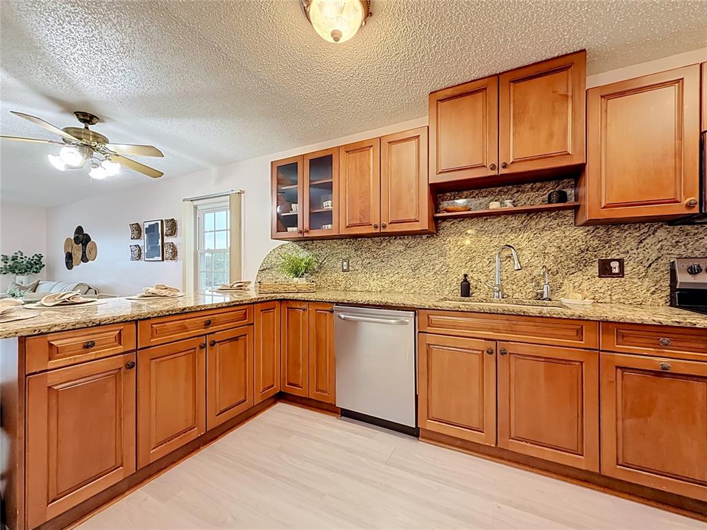 A kitchen with wood cabinets, granite countertops, and stainless steel appliances — 1900 68TH STREET N UNIT 301, ST PETERSBURG, FL