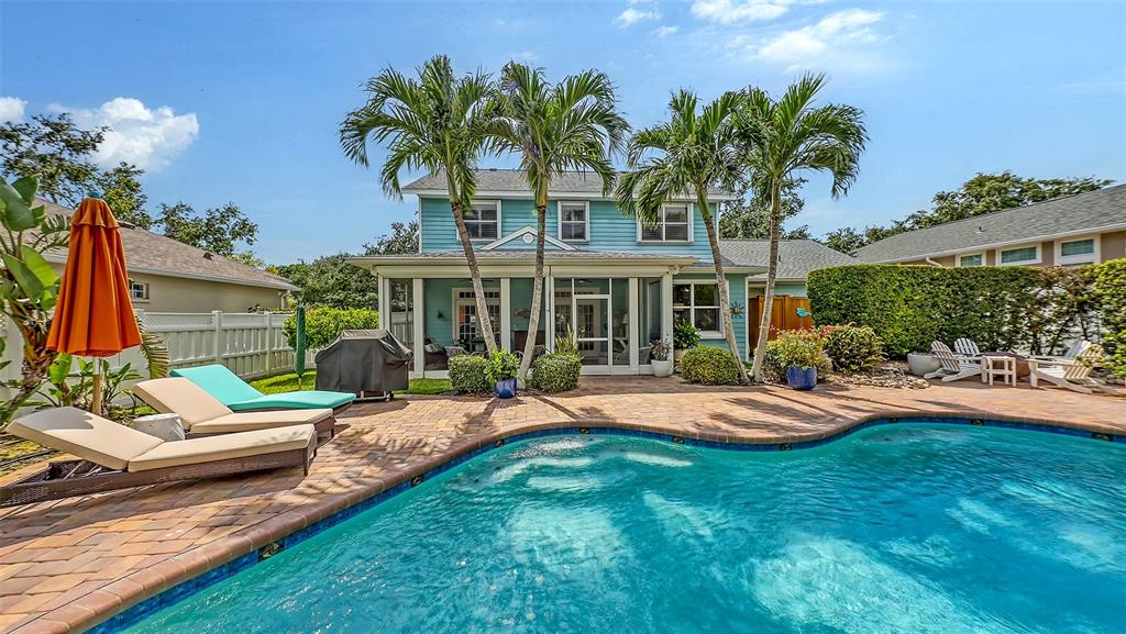 A two-story blue house features a backyard pool, patio, and palm trees — 1105 92ND STREET NW, BRADENTON, FL