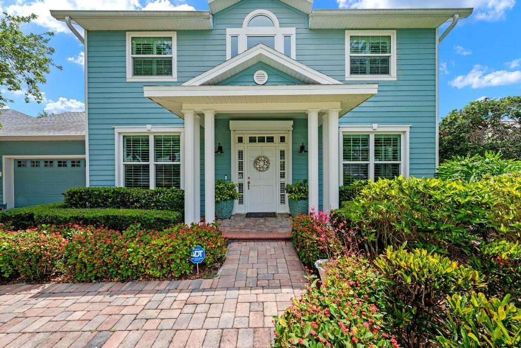 A two-story blue house with a brick walkway, white columns, and a front porch — 1105 92ND STREET NW, BRADENTON, FL