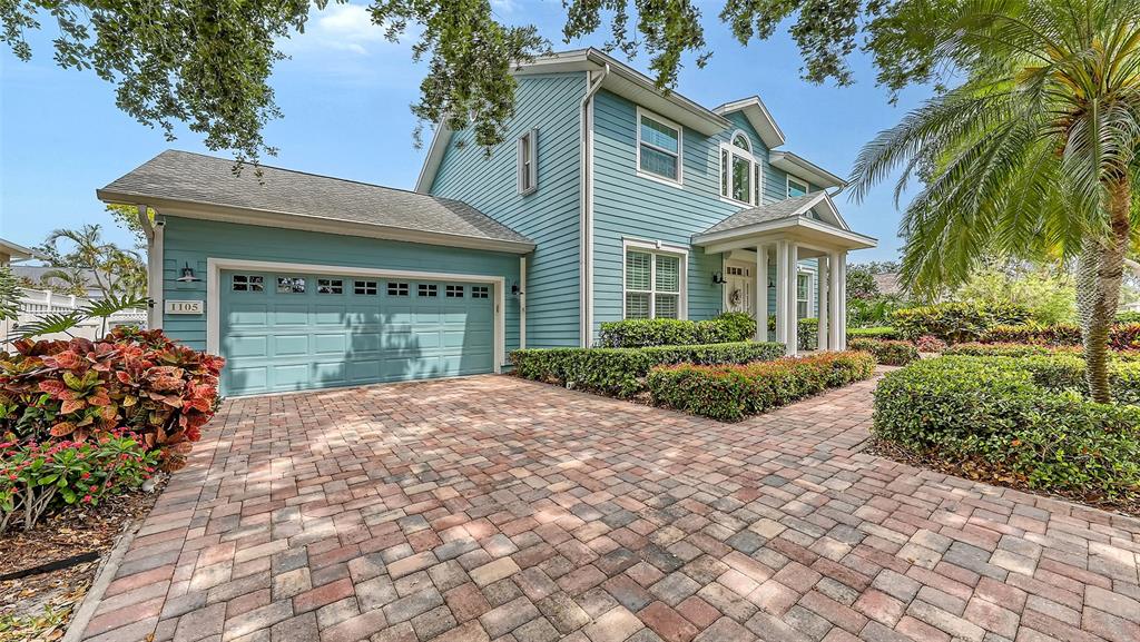 A two-story blue house with a brick paver driveway and a two-car garage — 1105 92ND STREET NW, BRADENTON, FL
