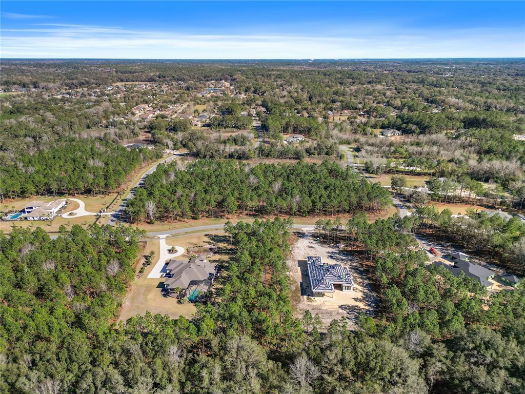 An aerial view shows two large houses surrounded by dense forest and residential streets — 2651 NW 152ND COURT, NEWBERRY, FL
