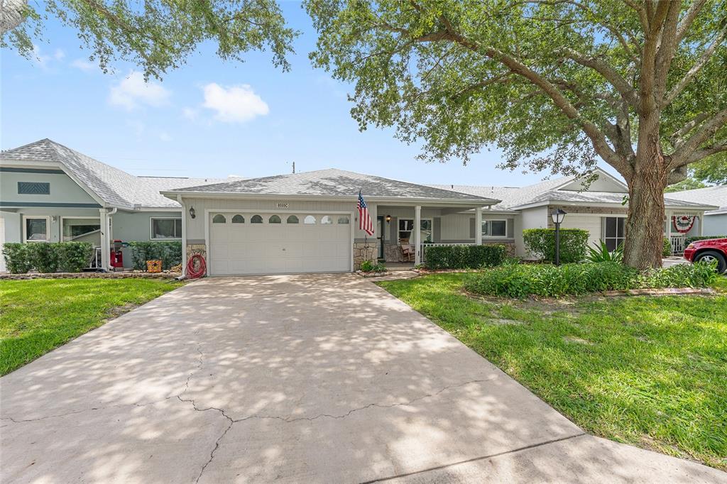 A single-story brick house with a two-car garage, concrete driveway, and a front porch — 9882 SW 88TH TERRACE UNIT B, OCALA, FL