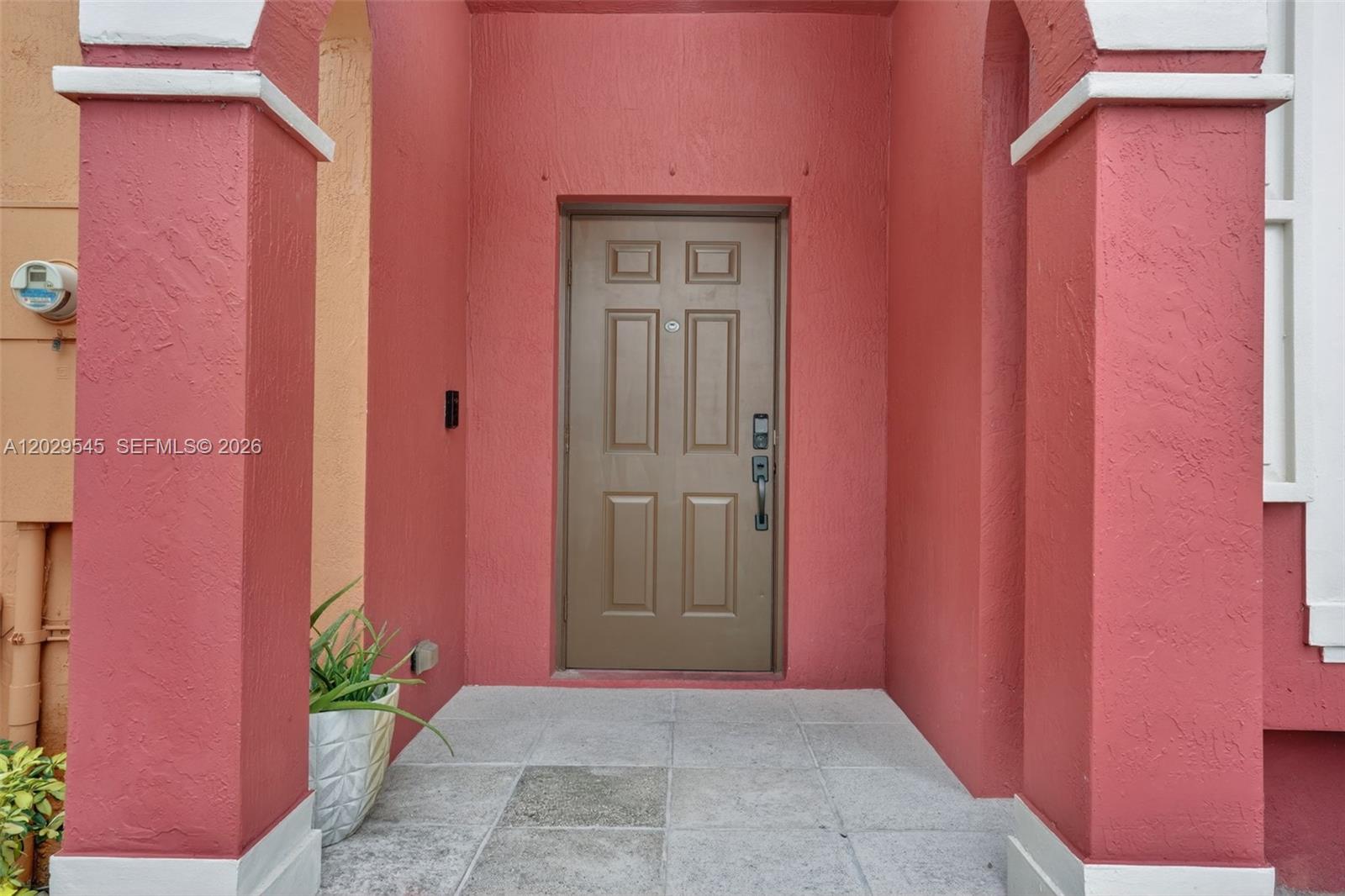 A brown front door is set within a recessed entryway with red stucco walls — 8904 SW 19th St, Miramar FL 33025, MIRAMAR, FL