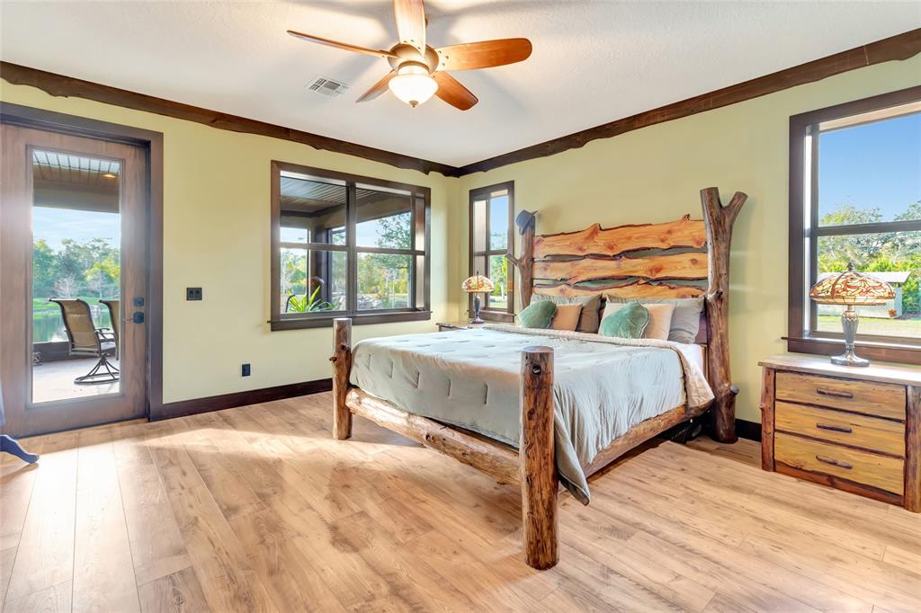 A bedroom features a rustic log bed frame, light green walls, and wood-look flooring — 7330 CRABGRASS ROAD, ST CLOUD, FL