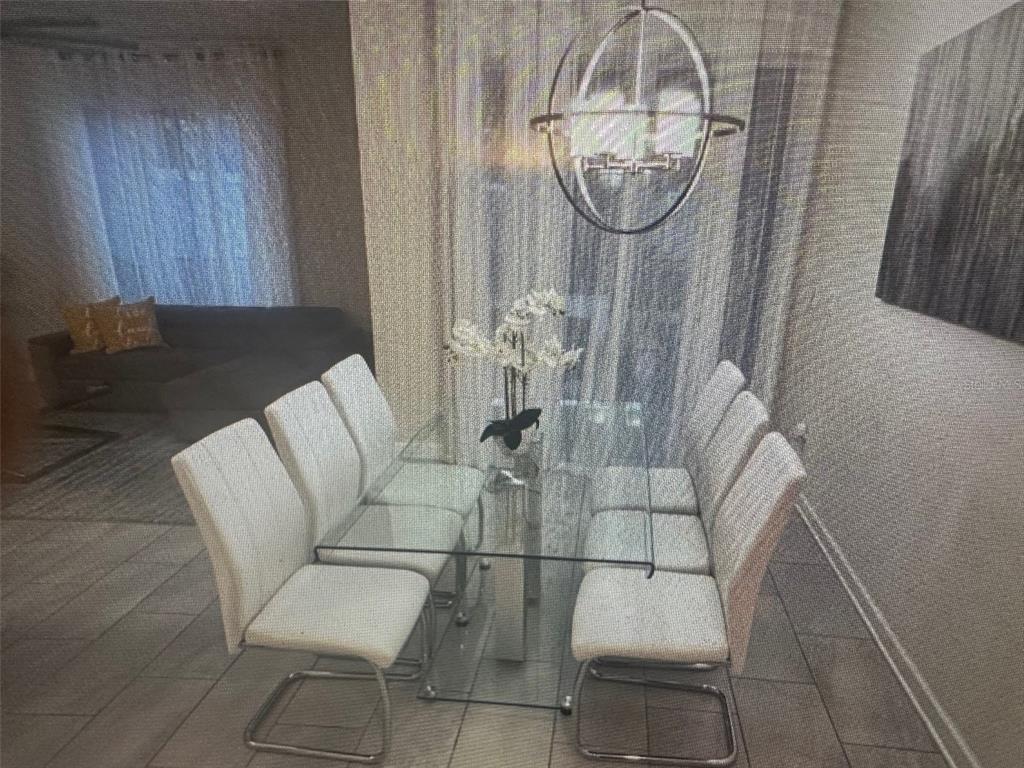 A dining room features a glass-topped table with six white chairs under a spherical chandelier — 4976 WINDERMERE AVENUE, KISSIMMEE, FL
