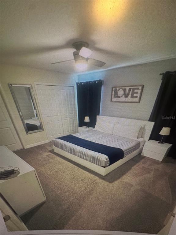 A bedroom features a platform bed, a ceiling fan, a mirror, and a wall sign — 4976 WINDERMERE AVENUE, KISSIMMEE, FL