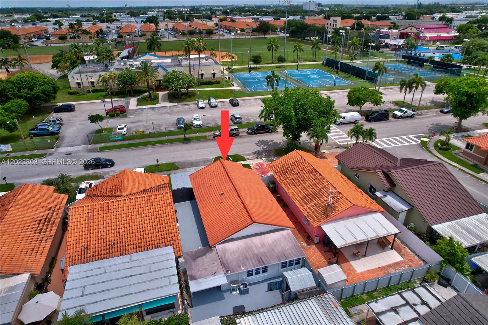 An aerial view shows a row of houses with orange tile roofs near a park — 2514 W 74th St, Hialeah FL 33016, HIALEAH, FL