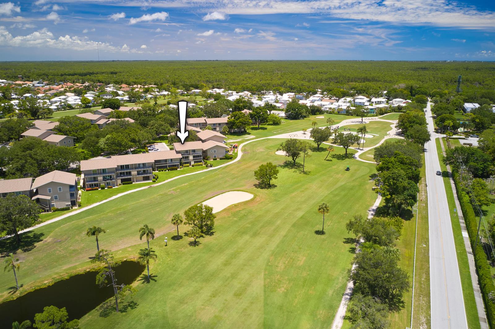 An aerial view shows a multi-story apartment building situated next to a golf course — 18439 SE Wood Haven Lane # M, Jupiter FL 33469, JUPITER, FL