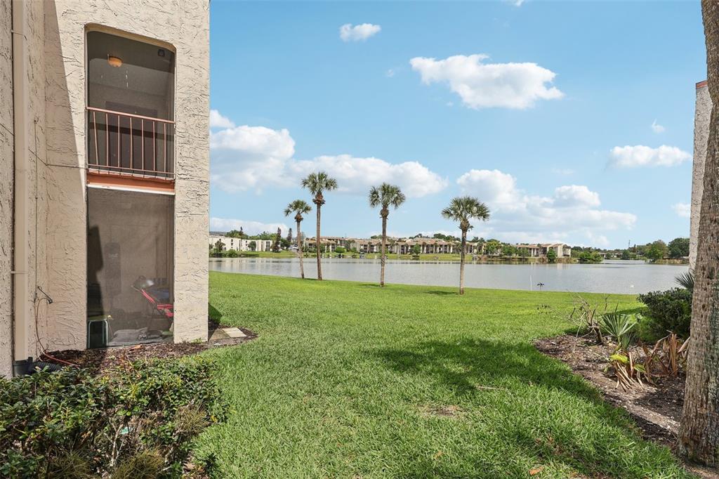 A view of a grassy lawn and lake from a ground-floor screened-in patio — 534 ORANGE DRIVE UNIT 27, ALTAMONTE SPRINGS, FL