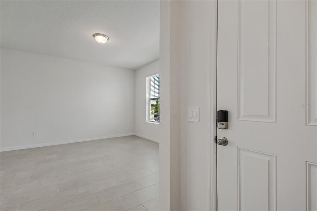 A view from a doorway into a room with white walls, tile flooring, and windows — 4512 HOMESTEAD TRAIL, ST CLOUD, FL